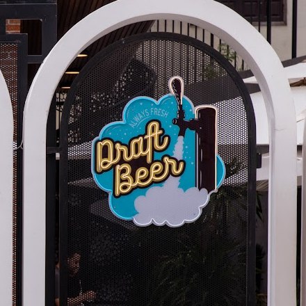 Biển đèn neon Draft Beer dưới những mái vòm trắng