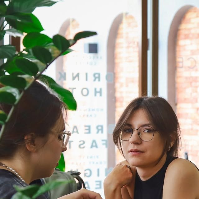 Two guests chatting by the window inside E-Space Coffee & Craft Beer