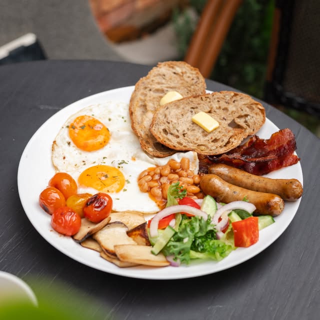 Bữa sáng đầy đủ với bánh mì sourdough, trứng, đậu và xúc xích
